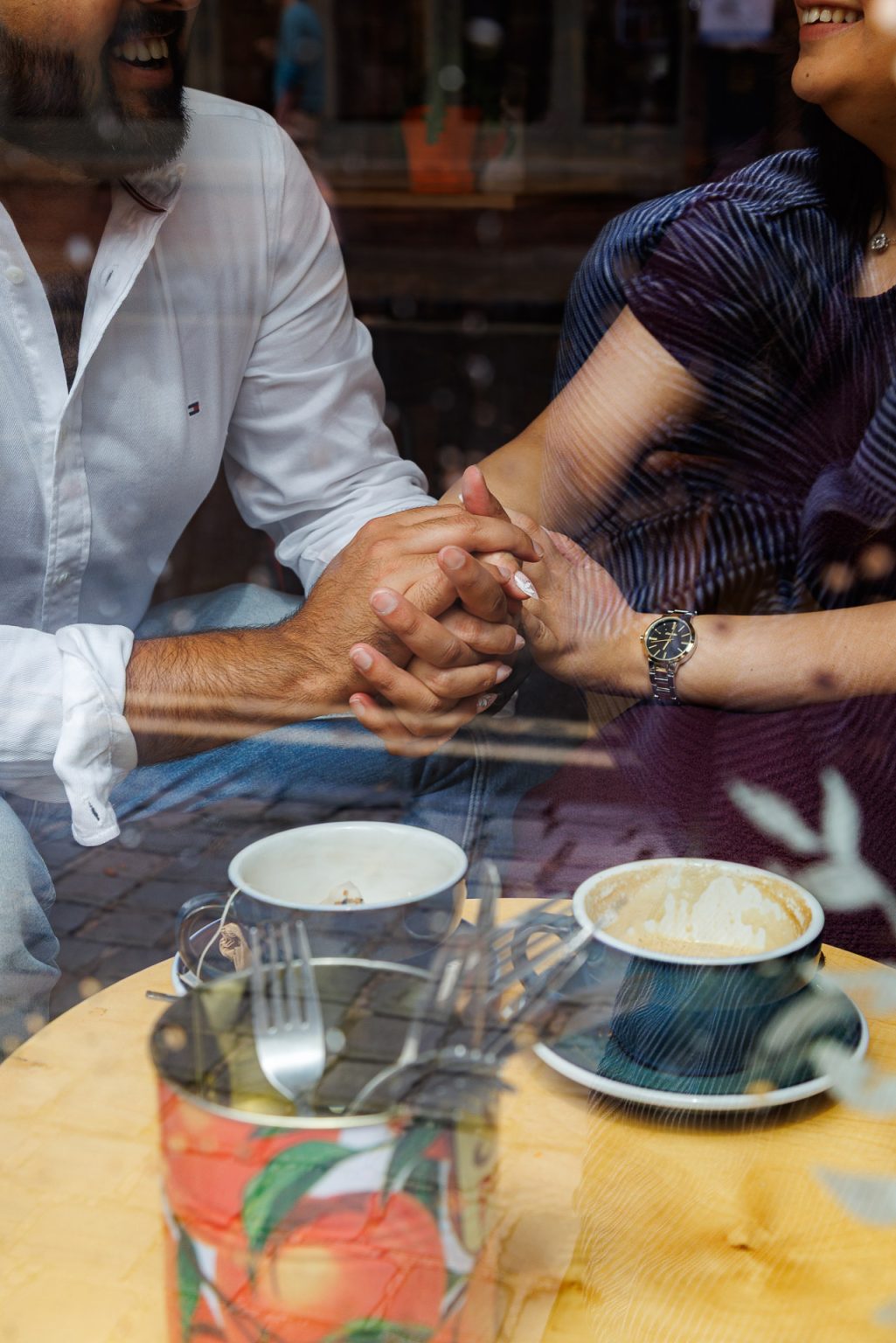 Jordan Taylor C Photography - closeup of couple's hands together during engagement shoot, sitting in front of a window in Oxford Old Firestation Cafe